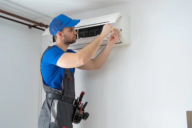 male technician overalls blue cap repairs air conditioner wall 353017 466 Home Solution India